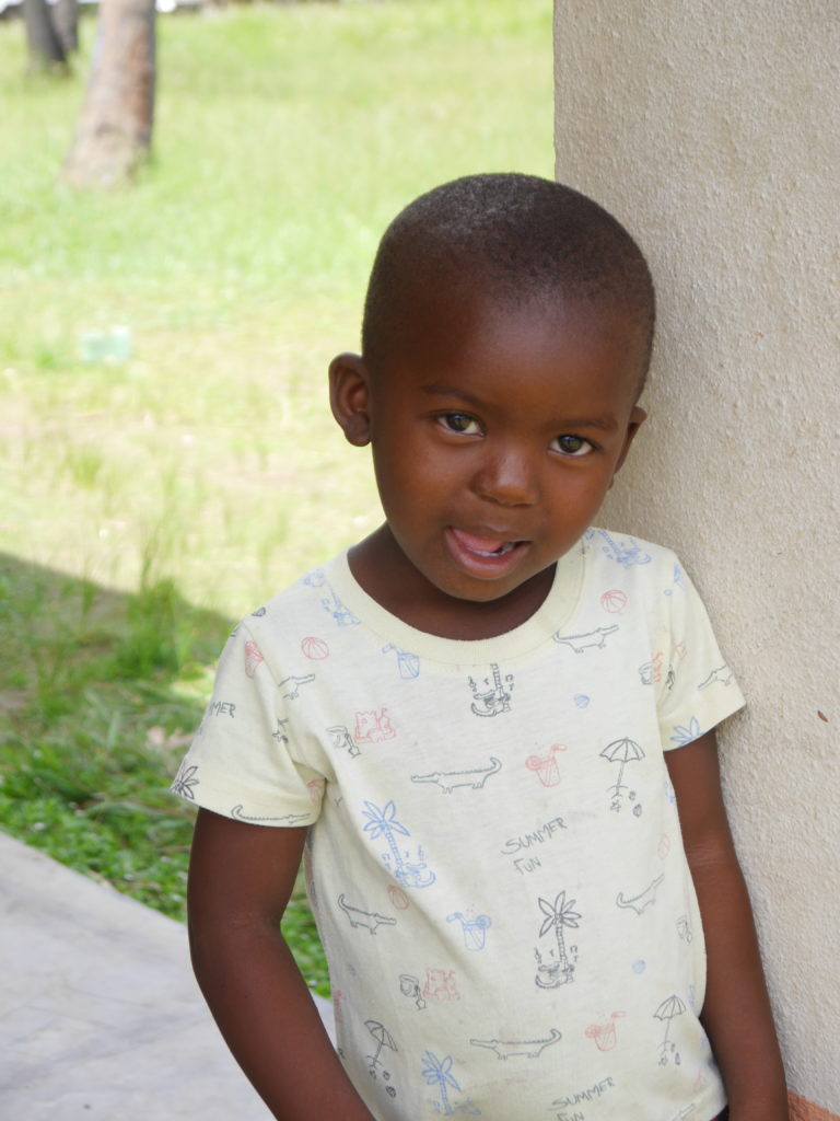 Eliable standing by his house at the Okalawo children's village in Mozambique